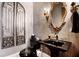 Elegant powder room with dark fixtures, ornate mirror, and decorative wall art at 833 Hines Rd, Moreland, GA 30259