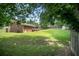Expansive backyard with green lawn, mature trees, a wooden fence, and a storage shed at 3464 Navaho Se Trl, Smyrna, GA 30080