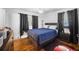 Bedroom with dark wood headboard, black curtains, and dark wood floors with a light-colored rug at 3464 Navaho Se Trl, Smyrna, GA 30080