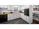 Well-lit kitchen with white cabinets, sleek black appliances, and a window over the sink at 3464 Navaho Se Trl, Smyrna, GA 30080