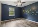 Bedroom with custom space themed wall art and wood flooring at 146 Pine St, Covington, GA 30014