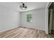 Bedroom with vinyl flooring, large window, ceiling fan, and closet at 146 Pine St, Covington, GA 30014