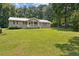 Single-story house surrounded by lush greenery and a well-kept lawn at 146 Pine St, Covington, GA 30014