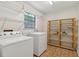 Well-lit laundry room with patterned vinyl floor and wire shelving, plus additional storage shelves at 146 Pine St, Covington, GA 30014