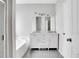 Bathroom with a double sink vanity, white cabinets, and a soaking tub at 2005 Chicago Nw Ave, Atlanta, GA 30314