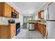 View of the kitchen with wood cabinets, stainless steel appliances, and an open view to the living area at 2005 Chicago Nw Ave, Atlanta, GA 30314