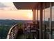 Outdoor condo patio with lounge seating and expansive city views during a vibrant sunset at 700 Park Regency Ne Pl # 1605, Atlanta, GA 30326