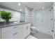 Well-lit bathroom featuring a glass-enclosed shower, neutral-toned tile, and white vanity at 700 Park Regency Ne Pl # 1605, Atlanta, GA 30326