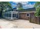 Back of house with brick exterior, sunroom, and an outdoor brick-paved patio at 865 Old Creek Trl, Atlanta, GA 30328
