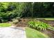 Multi-tiered backyard garden with retaining walls, lush plants, and landscaped greenery at 865 Old Creek Trl, Atlanta, GA 30328