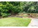 Backyard featuring tiered retaining walls showcasing landscaped foliage for added privacy and beauty at 865 Old Creek Trl, Atlanta, GA 30328