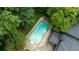 Aerial view of a backyard swimming pool with a surrounding patio and mature trees for shade and privacy at 865 Old Creek Trl, Atlanta, GA 30328