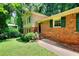Charming brick home featuring green shutters, established landscaping and a manicured lawn at 2802 Leisure Woods Ln, Decatur, GA 30034