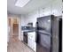 Well-lit kitchen featuring white cabinets, a black refrigerator, and luxury vinyl plank flooring at 2802 Leisure Woods Ln, Decatur, GA 30034