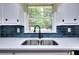 Bright kitchen with quartz counters, a subway tile backsplash, and a stainless steel sink beneath a window at 2802 Leisure Woods Ln, Decatur, GA 30034