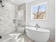 Luxurious bathroom featuring soaking tub, glass-enclosed shower, and marble accents at 490 Hammons Way, Atlanta, GA 30315