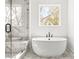 Modern bathroom features a soaking tub with a window and a glass-enclosed marble shower at 490 Hammons Way, Atlanta, GA 30315