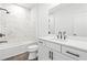 Modern bathroom features a tub shower, white vanity, and marble tile walls at 490 Hammons Way, Atlanta, GA 30315