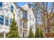 Charming three-story townhouse featuring a balcony, black trim, and well-maintained landscaping at 490 Hammons Way, Atlanta, GA 30315