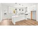 Open kitchen with island, pendant lighting, white cabinets and stainless steel appliances at 490 Hammons Way, Atlanta, GA 30315