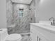 This luxurious bathroom features marble-style tile, a shower with a bench, and a sleek vanity at 85 Ollie St, Atlanta, GA 30314