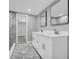 Bathroom featuring double vanity, marble-look tile, and a glass door to the shower at 85 Ollie St, Atlanta, GA 30314