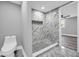 Bathroom shower featuring marble-look tile, river rock floor, and built-in niche at 85 Ollie St, Atlanta, GA 30314