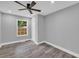 A modern grey bedroom features vinyl plank flooring, a ceiling fan, and a window with natural light at 85 Ollie St, Atlanta, GA 30314