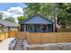 Charming single-Gathering home with a modern blue exterior and a stylish wooden fence for privacy at 85 Ollie St, Atlanta, GA 30314