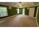 Large bedroom featuring green paint, neutral carpet, two windows, and access to a door at 1855 Tribble Ridge Dr, Lawrenceville, GA 30045