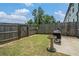 Fenced backyard with a small grass area, grill, bird bath, and a small concrete patio at 211 N Auburn Landing Pl, Auburn, GA 30011