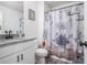 Bathroom featuring floral shower curtain and granite vanity top, with an accompanying mirror and toilet at 211 N Auburn Landing Pl, Auburn, GA 30011