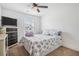 Comfortable bedroom with ceiling fan, carpet, large window, and a queen-sized bed with purple floral bedding at 211 N Auburn Landing Pl, Auburn, GA 30011