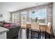 Cozy dining area bathed in natural light, complemented by a brick accent wall and hardwood floors at 211 N Auburn Landing Pl, Auburn, GA 30011