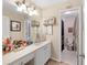 Well lit vanity area with a white sink, large mirror and framed decorations leading to toilet and shower at 29 Sedgefield Overlook, Dallas, GA 30157