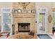 Stone fireplace with gas logs, flanked by windows and a doorway to the exterior of the home at 29 Sedgefield Overlook, Dallas, GA 30157
