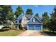 Charming two-story blue home with stone accents, lush landscaping, and a convenient two-car garage at 29 Sedgefield Overlook, Dallas, GA 30157