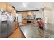 A kitchen with stainless steel refrigerator, granite countertops, and light wood cabinetry at 29 Sedgefield Overlook, Dallas, GA 30157