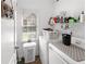 Bright laundry room with white washer and dryer, storage shelves, and window at 29 Sedgefield Overlook, Dallas, GA 30157