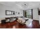 Elegant living room featuring dark hardwood floors, a large mirror, stylish decor, and balcony access with city views at 325 E Paces Ferry Ne Rd # 1910, Atlanta, GA 30305
