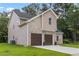 Side view of a two-story home with a two-car garage, brick and siding, and a lush green lawn at 3405 Summer Brooke Way, Union City, GA 30291