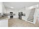 Large kitchen with white cabinets, granite countertops, stainless appliances, and stairs to a second level at 3405 Summer Brooke Way, Union City, GA 30291