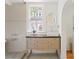 Bathroom with a vintage vanity, large window, oval mirror, and light tile walls at 694 Peeples Sw St, Atlanta, GA 30310