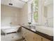 Bright bathroom featuring tile walls, a claw foot tub, vintage vanity, and lots of natural light at 694 Peeples Sw St, Atlanta, GA 30310