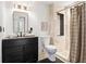 Bathroom featuring a large framed mirror, black vanity, and tiled shower with neutral tones at 694 Peeples Sw St, Atlanta, GA 30310