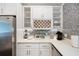 Well-lit kitchen with stainless steel refrigerator, white cabinets, mosaic backsplash, and countertop appliances, ideal for cooking at 1463 Macklone Ne St, Atlanta, GA 30307