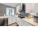Bright kitchen with stainless steel appliances, white cabinets, and stylish backsplash, offering a contemporary and inviting cooking space at 1463 Macklone Ne St, Atlanta, GA 30307