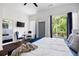 Bright main bedroom features dark wood floors, ensuite bath, and balcony access with beautiful views of green scenery at 1463 Macklone Ne St, Atlanta, GA 30307