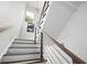 Modern staircase with wooden steps, white risers, and stylish metal railing leading to the upper level of the home at 1463 Macklone Ne St, Atlanta, GA 30307