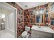 Quirky bathroom with book wallpaper, white vanity and toilet, plus a shower/tub combo at 1781 Point Pleasant Se, Smyrna, GA 30080